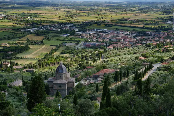 Yaz mevsiminde İtalya 'nın Toskana bölgesindeki Arezzo ilindeki Cortona' dan panoramik manzara. Santa Maria delle Grazie al Calcinaio