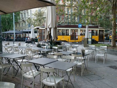 Milano, Lombardiya, İtalya 'da masalar ve sarı tramvay