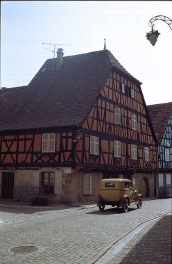 Kientzheim, Alsace, Grand Est region, France: exterior of typical half-timbered houses and vintage car clipart