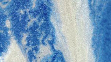 Parlak mürekkep. Parlak sıvı dokusu. Kar kristali akışı. Mavi beyaz renkte parıldayan metalik boya dökülmüş su bulanık sanat arkaplanda harmanlanmış hareket.