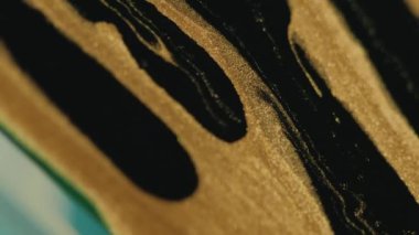 Parıltılı boya döküldü. Sıvı arkaplan. Köpüklü sıvı. Altın siyah renkli titreşimli parçacıklar mürekkep damlaları soyut sanat dokusuna damlıyor.