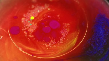 Suyu boya. Parlak yağ balonu. Odaklanmamış parlak kırmızı pembe renkli karışık mürekkep dokusu ıslak jel sıvısı damla yüzen soyut arkaplan.