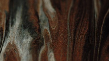 Parıltı damlıyor. Boya akışı. Odaklanmamış beyaz kahverengi bronz renk ışıl ışıl metalik doku sıvı kademeli aynalı soyut sanat arka planı.