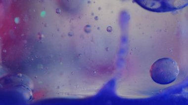 Jöle baloncukları. Jel yağı damlası. Mürekkep suyu. Odaklanmamış neon mavisi mor yarı şeffaf sıvı boya daireler yüzen hareket sanatı soyut arkaplan.