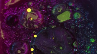 Soyut arkaplan. Sıvı karışımı. Renkli akrilik kabarcıklar. Neon parıltısı deseni sarı menekşe yağı lekeli su sanatında hareket eder..