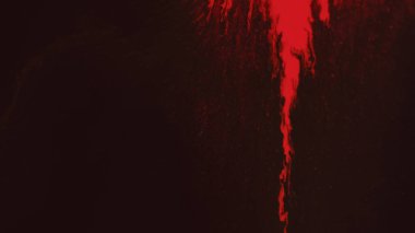 Boya dökülüyor. Parlak mürekkep döküldü. Sıvı karışımı. Kırmızı boya lekesi koyu siyah sanat soyut grunge arkaplan üzerinde akış hareketini yayıyor..