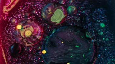 Soyut arkaplan. Sıvı karışımı. Renkli akrilik kabarcıklar. Neon parıltısı deseni sarı menekşe yağı lekeli su sanatında hareket eder..