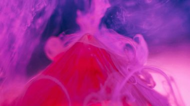 Mürekkep arkaplanı. Renk dumanı. Sis sanatı. Kırmızı piramidin tepesindeki neon pembe dokuma sisi ve menekşe üzerindeki Bokeh soyut parçacıkları..