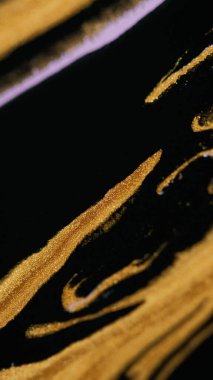 Parıltılı boya döküldü. Sıvı arkaplan. Köpüklü sıvı. Altın siyah renkli titreşimli parçacıklar mürekkep damlaları soyut sanat dokusuna damlıyor.