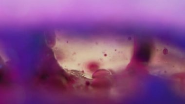 Jel sıvısı sıçraması. Mürekkep kabarcığı. Serum emülsiyon dokusu. Su hareketi sanatının soyut arka planında odaksız, mor, mavi, şeffaf, nemli boya damlası..