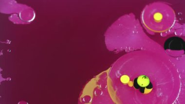 Soyut arkaplan. Boya baloncukları. Renkli yağ suyu. Pembe parlak, siyah, parlak daireler hipnotik, yaratıcı sıvı sanatta hareket ediyor..