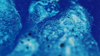 Işıldayan boya arka planı. Mürekkep karışımı. Sıvı karışımı. Parlayan odaksız mavi pullar soyut moda akrilik pigment sanatı.