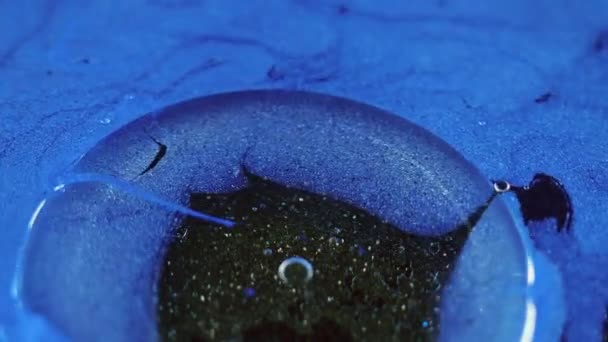 抽象的な背景 流動的なアートテクスチャ オイルの液体消毒 青い光沢のある粒子のインクの表面に黒いシーン底で広がる透明な脂肪質の汚れ — ストック動画