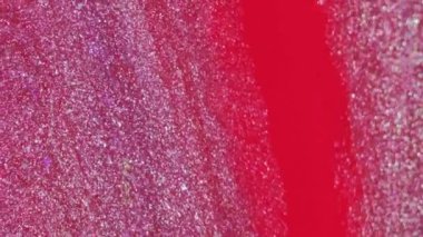 Köpüklü sıvı. Parlak boya dokusu. Pembe kırmızı renk, parlak metalik mürekkep dökülmesi. Karışık dalga hareketi, bulanık serbest alan arkaplanı üzerinde..