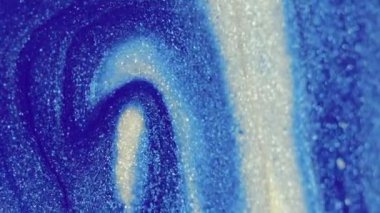 Işıldayan mürekkep akışı. Sıvı doluyor. Bulanık sanat arkaplanda parlak mavi renkli metalik desen akrilik boya akışı.