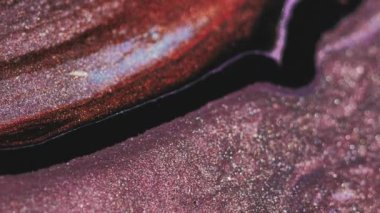 Parlak sıvı arka plan. Parlak sıvı akışı. Renkli kum. Pembe altın sarısı, siyah, ışıldayan parçacıklar soyut sanata yayılıyor..