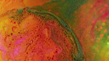 Soyut arkaplan. Sıvı boya karışımı. Işıldayan akış. Renkli kontrast sarı yeşil turuncu kabarcıklar doku sıvısı suya yayılıyor yaratıcı sanatta ışıltılı taban.