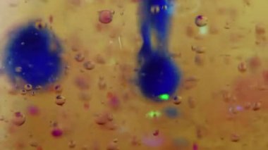 Mürekkep damlası. Jöle baloncukları. Yağ emülsiyonu. Odaklanmamış sarı pembe renk şeffaf parlak sıvı mürekkep damlası yüzen soyut sanat arkaplanı.