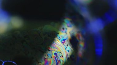 Neon boya. Holografik sıvı. Psikedelik rüya. Koyu mavi soyut sanat arka planında odaklanmış hafif yağ kabarcığı sıvı mürekkep karışımı kaotik hareket.