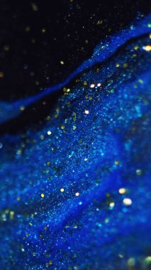 Parıltı damlaları akar. Parlak mürekkep dokusu. Odaklanmamış altın sarısı mavi renk parıldayan boya dalgası hareketli soyut sanat arkaplanı.