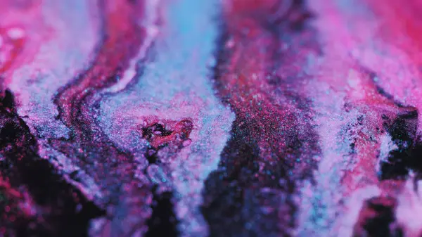 Glitter fluid drip. Ink mix wave. Defocused bright purple pink blue black color sparkling particles texture liquid blend spill motion abstract art background.