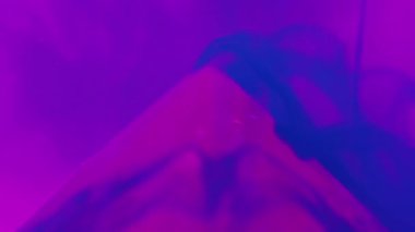 Su pigmenti arka planı. Mürekkep akışı. Renk buharı sıçraması. Pembe piramidin üzerindeki parlak mavi sıvı boya soyut neon sanatıyla kaplı..