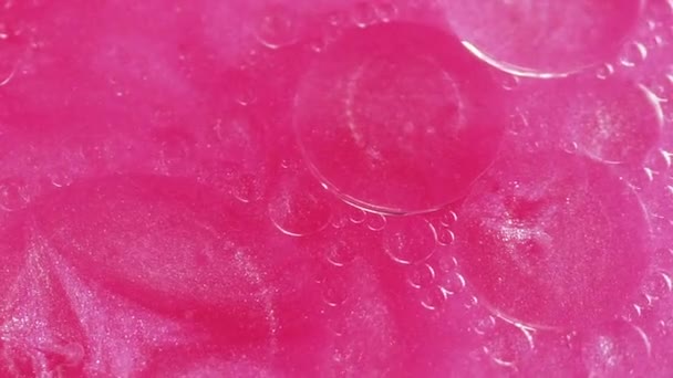 抽象的な背景 スパークリング液 カラフルなオイルサークル 光沢のあるピンクの輝く粒子の光沢のあるインクアートの水面の動きを浮かべる脂肪の円形の斑点 — ストック動画