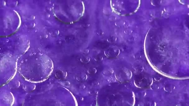 抽象的な背景 光沢のある流体ミックス フローティングバブル液 透明な酸素の円は明るいバイオレットの光沢のある物質の表面で輝きます — ストック動画