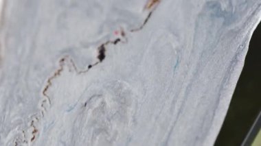 Parlak boya damlıyor. Mermer mürekkep dökülmüş. Odaklanmamış metalik altın sarısı, beyaz, yeşil, parlak desen sıvısı, akış hareketi, soyut sanat arkaplanı..