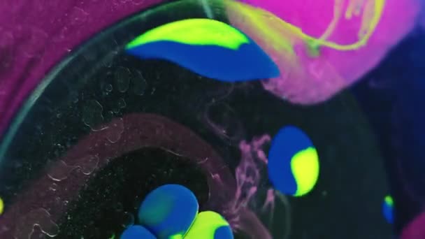 オイルペイントバブル インクウォータードロップ 暗黒アート抽象的な背景に浮かぶ鮮やかな黄色の紫色色のぬれたゲル液体円 — ストック動画