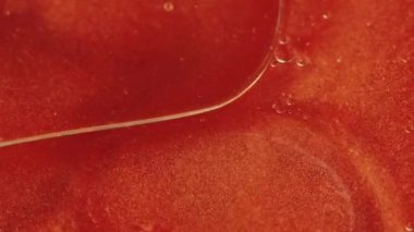 Soyut arkaplan. Sıvı simli boya. Yağ damlası yüzeyi. Şeffaf yağ lekeleri büyüleyici sanatta parlak turuncu parçacıklar içeriyor..