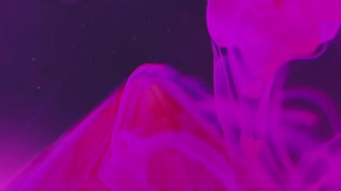 Mürekkep arkaplanı. Buhar sıvısı. Su altı dumanı. Kırmızı taş piramidin üzerine flüoresan pembe soyut damla sıvı içinde, gerçek üstü menekşe sanatında çözülmüş bokeh parçacıkları ile..