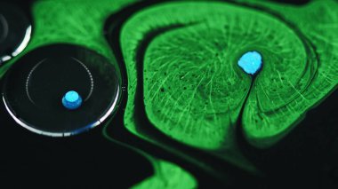 Suyun içine boya damlıyor. Yağ sıvısı. Odaklanmamış yeşil renkli jel sıvısı mürekkep baloncukları karışık hareketli soyut sanat arkaplanı yayıyor.