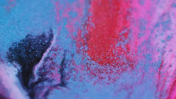 Glitter fluid drip. Ink mix wave. Defocused bright purple pink blue black color sparkling particles texture liquid blend spill motion abstract art background.
