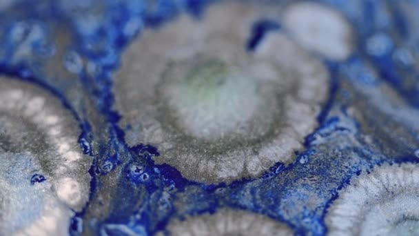 ペイントドロップ グリッターフルードスプラッシュ 分割された青い銀色の光沢のある輝く質のインクの光沢のあるスプラッターの混合物の動き抽象的な芸術の背景 — ストック動画