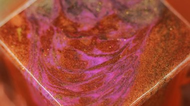 Parıltılı boya karışımı. Bokeh ışığı. Bronz turuncu pembe parlak desenli mürekkep akışı sıvı hareket geometrik küp şekilli soyut sanat arka planı.