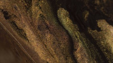 Boya akışı. Islak sim dokusu. Odaklanmamış sarı siyah pembe renk parıldayan sıvı mürekkep karışımı dalga hareketi soyut sanat arkaplanı.