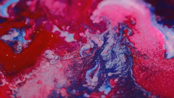 Islak boya arka planı. Pigment sıvısı. Renkli girdaplar. Parlak kırmızı, mavi, parıldayan parçacıklar. Boya, soyut dalgaları büyüler..