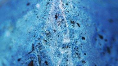 Işıldayan mürekkep arka planı. Islak pigment. Parlak akış. Parlak mavi sıvı ve siyah madde yüzeyde yayılıyor soyut bir harmanla..