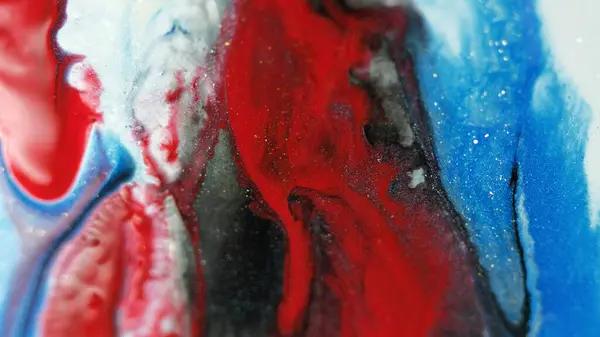 Glitter paint drip. Ink spill. Defocused red blue white black color shimmering texture acrylic fluid drop flow motion abstract art background.