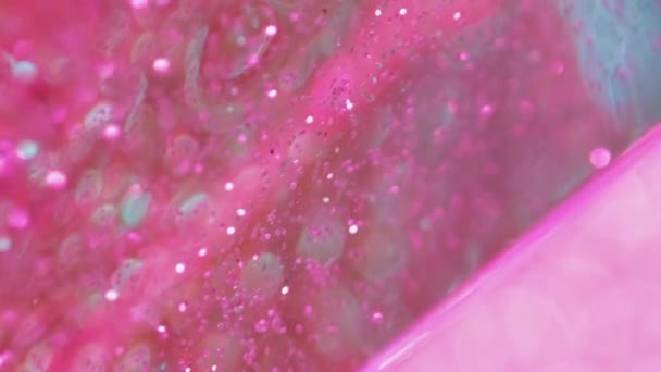 バーティカルビデオ グリッターフローの背景 マジック液体 抽象的な鮮やかな芸術で変化する色を広めるボケの丸い斑点が付いているピンクの緑の光沢のある光沢のある水 — ストック動画