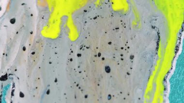 Soyut arkaplan. Pigment karışımı. Renkli dökülme. Makro sanatta turkuaz yüzeyine yayılan siyah lekeli, parlak sarı bej..
