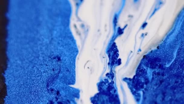こぼれを塗る グリッターインクドリップ 分解された青い白い色光る粒子ボケの光の質の流動波のカスケードの動き抽象的な芸術の背景 — ストック動画