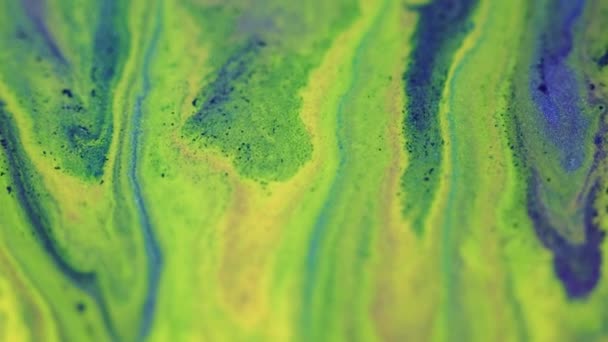 こぼれを塗る グリッターインクフロー 分割された緑色の黄色の青色の輝く質の流動スプラッシュ波の動きの装飾的な抽象的な背景 — ストック動画