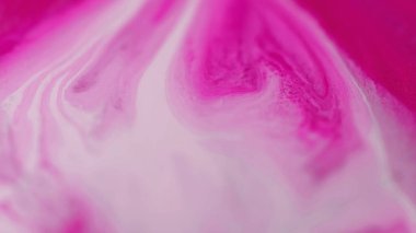 Mürekkep damlası. Sıvı dökülmesi. Odaklanmamış pembe beyaz pigment sıvı boya damlaları hareket yaratıcı sanat soyut arka plan yayıyor.