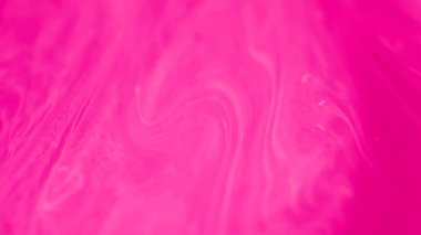 Pigment girdapları. Boya karıştırılmış su. Neon sisi. Pembe, parlak, göz kamaştırıcı pembe mürekkep akıntısı dalga resimlerini soyut arka planda yayıyor..