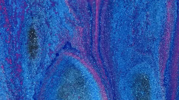 Glitter fluid spill. Paint mix. Defocused neon blue pink color sparkling particles texture liquid ink flow cascade abstract art background.