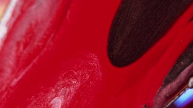 Sıvı boya arka planı. Işıldayan damlalar. Kahverengi renk parıltılı sıvı mürekkep soyut damlası kırmızı pürüzsüz doku yüzeyine yayılıyor canlı hipnotik sanatla.