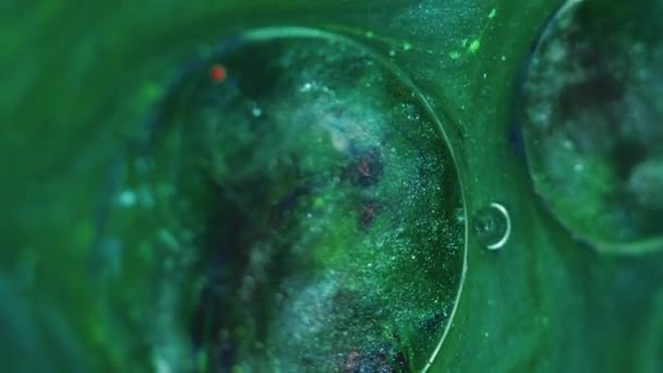 光沢のある流動的な背景 液体グリッターミックス オイルインク浮遊 シルバーブラック染料 緑色の催眠抽象的な渦巻き水に脂肪透明な低下で光る粒子 — ストック動画