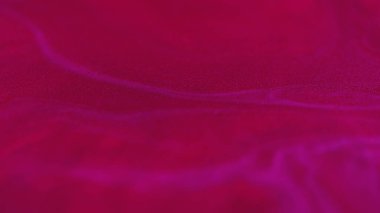 Işıldayan doku. Parıltılı boya. Bulanık neon pembe renk parlak parçacıklar sıvı mürekkep karışımı su dalgası sanat soyut zemin.